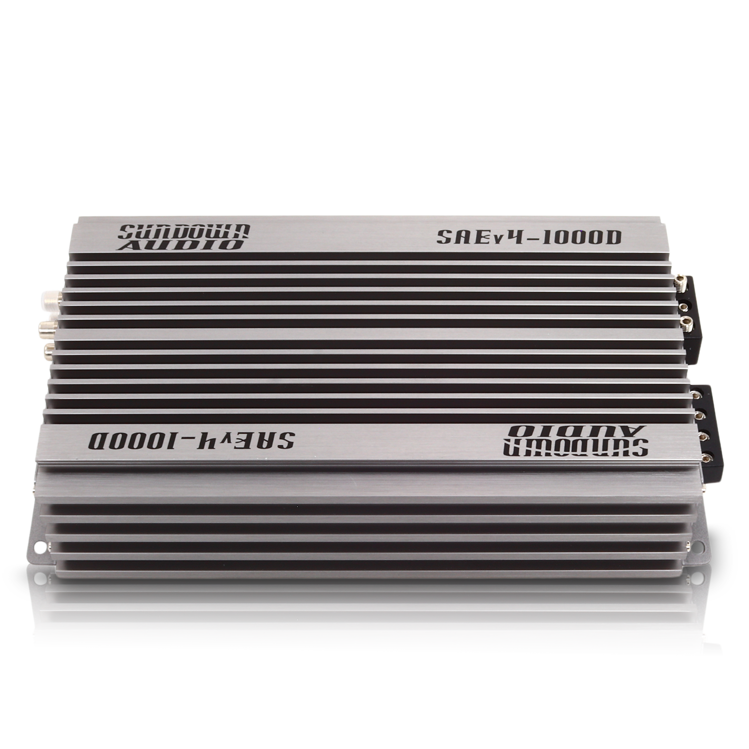 The Sundown Audio SAEv4-1000.1D Mono Amplifier features a sleek silver-colored, finned exterior for heat dissipation, black accent panels, and conveniently placed input/output connectors on one side.
