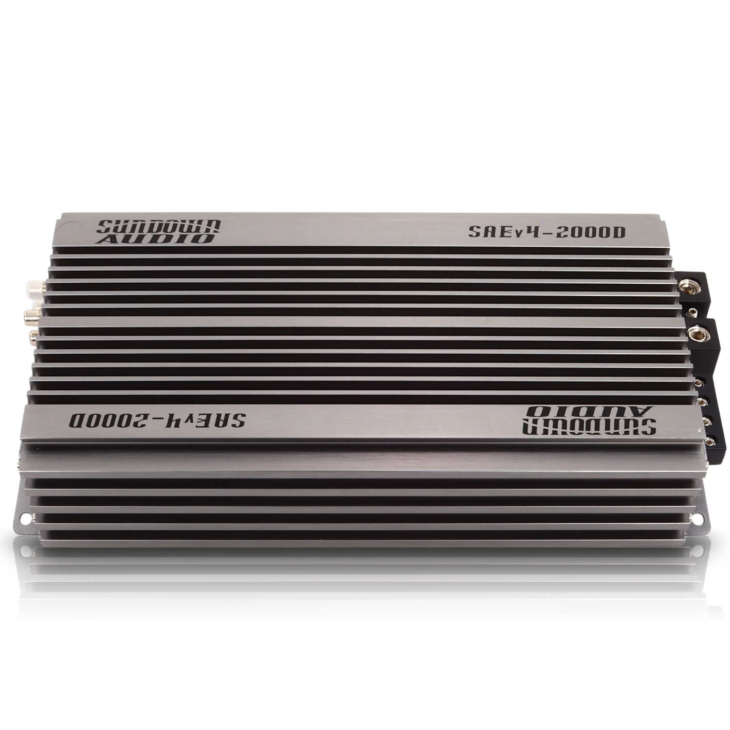 A rectangular Class D car amplifier, the Sundown Audio SAEv4-2000.1D, features a sleek silver finish with black cooling fins and thermal control. It has visible input and output connections on one side and is labeled on the top surface for optimal performance.
