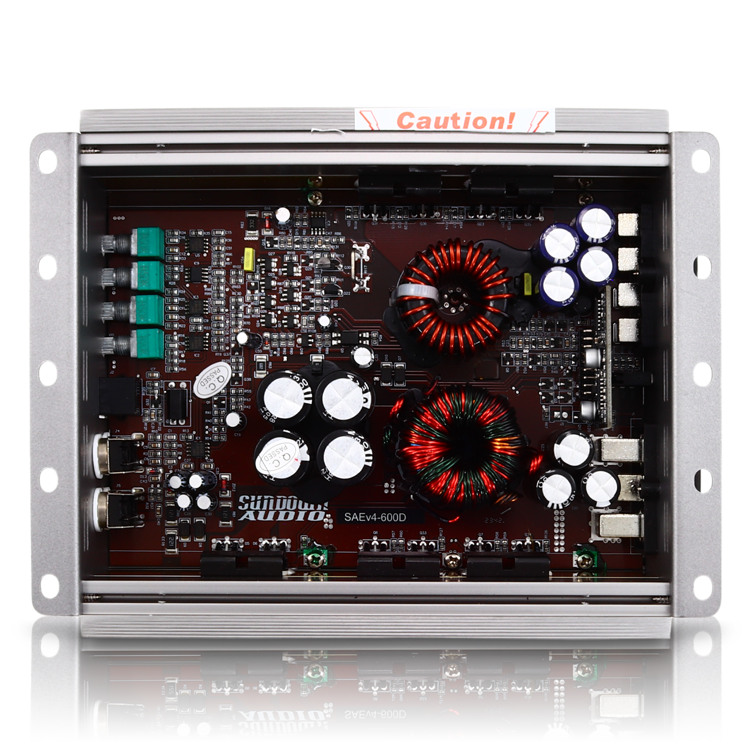 The interior of the Sundown Audio SAEv4-600.1D Mono Amplifier, a Class D car audio amplifier, displays components such as capacitors, coils, and a circuit board. The metallic enclosure with mounting brackets features a Caution! label on its top edge.