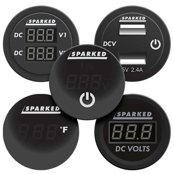 A set of five round black digital displays labeled Sparked. They show various readings: voltage, percentage, and temperature. Each has a different display style and a central power button on one.