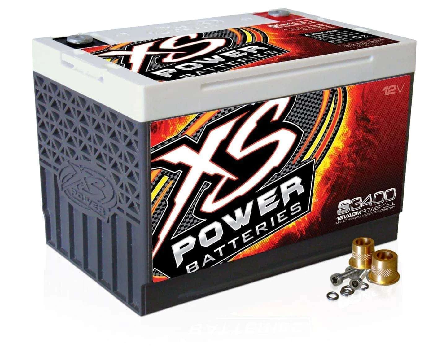 Image of the XS Power S3400 12VDC AGM Racing Vehicle Battery. The battery features dynamic red and orange graphics with the text "12V" prominently displayed in the upper right corner. Several metal connectors are positioned alongside it.