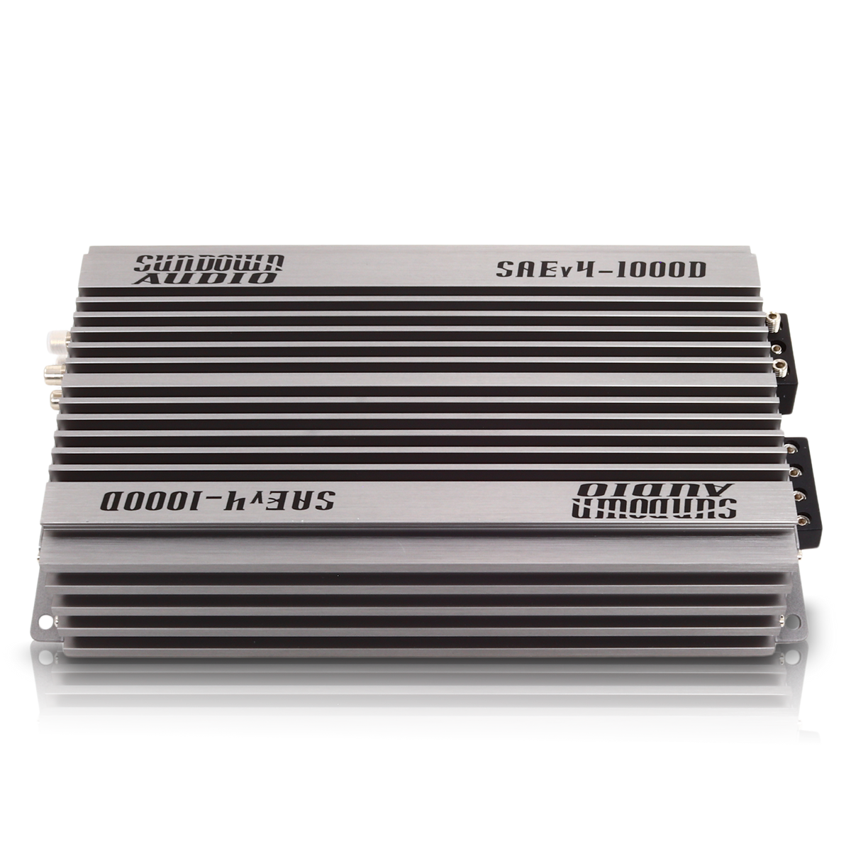 The Sundown Audio SAEv4-1000.1D Mono Amplifier features a sleek silver-colored, finned exterior for heat dissipation, black accent panels, and conveniently placed input/output connectors on one side.
