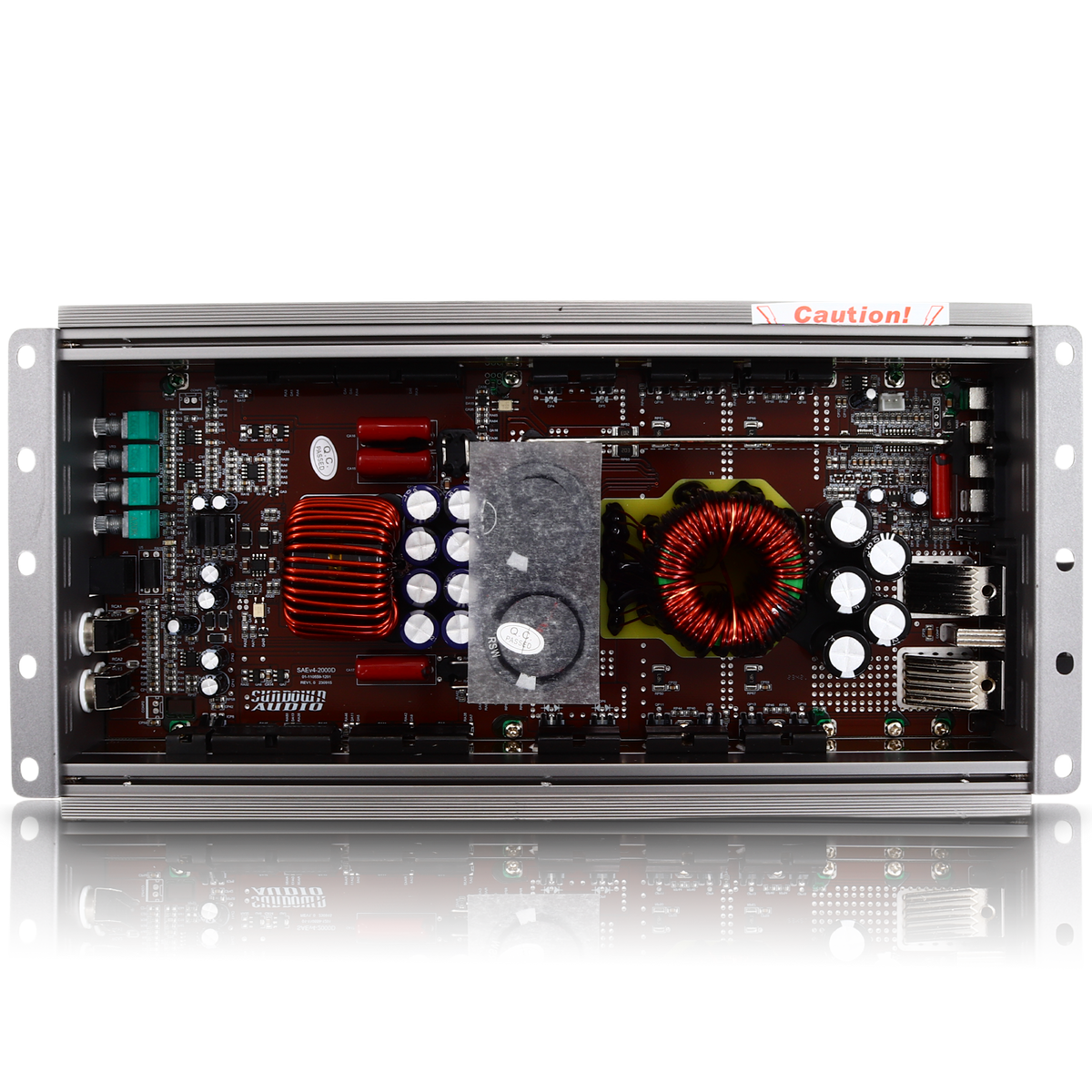 Interior view of the Sundown Audio SAEv4-2000.1D Amplifier circuit board with capacitors, coils, and other thermal control components inside a metallic frame. A red label at the top says Caution! The board reflects below.