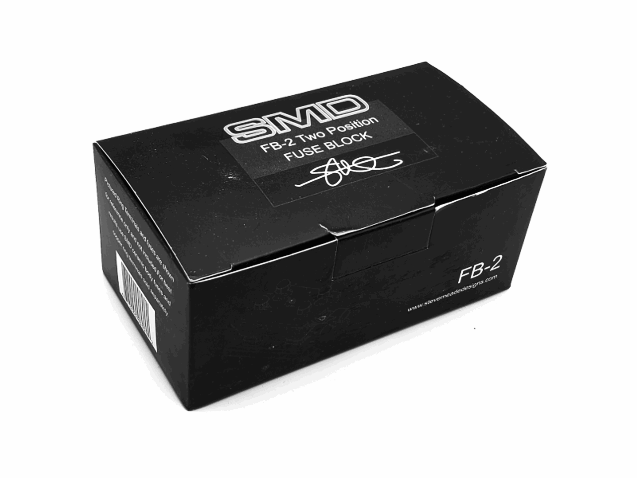 The black rectangular box showcases the SMD FB-2 Double Fuse Block by Steve Meade Designs, ideal for aftermarket sound systems. One side of the box is adorned with a logo along with white text and barcode details.