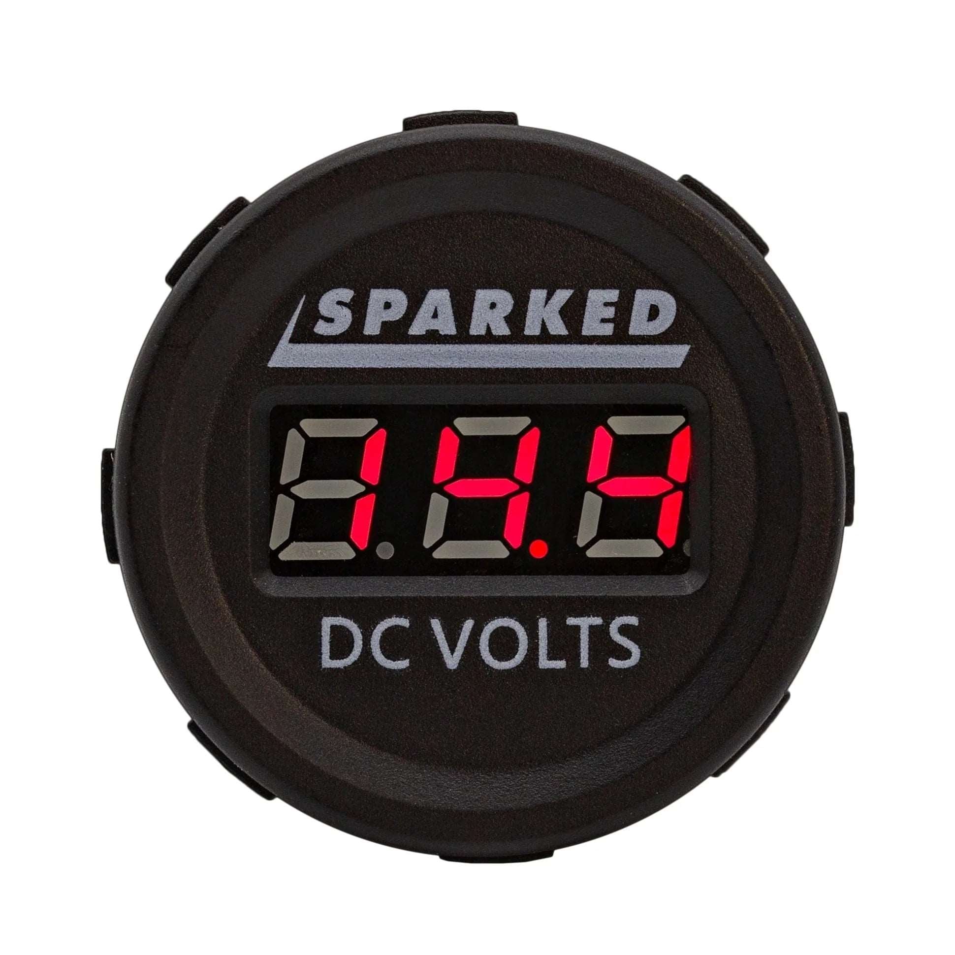 The Single 12VDC Voltmeter Battery Voltage Monitor by Sparked Innovations boasts a striking LED display with vivid red numbers reading 13.8. The brand name "Sparked" is elegantly positioned above, with "DC VOLTS" labeled below. Encased in a sleek black design with button-like sides, this device is IP67 waterproof, providing robust protection against the elements.