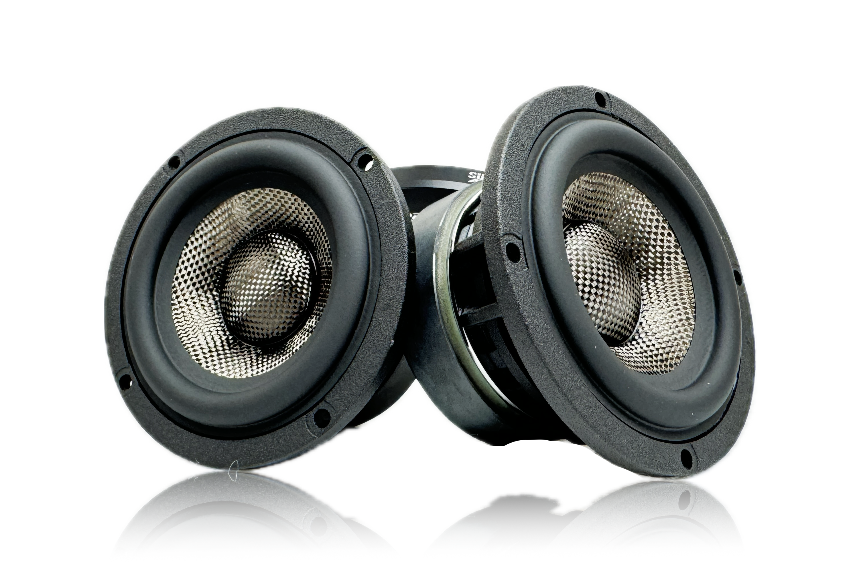 A pair of Sundown Audio SA-Series SA-3M 3" speakers from Sundown Audio, featuring a sleek black outer ring and metallic center, are placed side by side on a reflective white surface. The durable metal grille protects the visible mesh cones and ensures full-range sound quality.