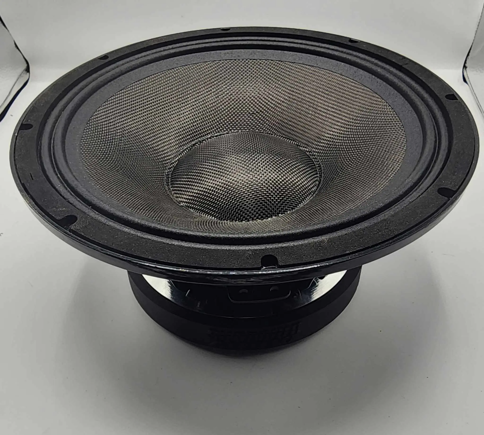 A close-up image of the Sundown Audio VEX-12 500W 12" Pro Audio Midrange Speaker reveals a large black speaker featuring a textured carbon-fiber cone and round frame. Set against a white background, it accentuates its detailed design and metallic sheen, emphasizing its high-efficiency mid-range capabilities.