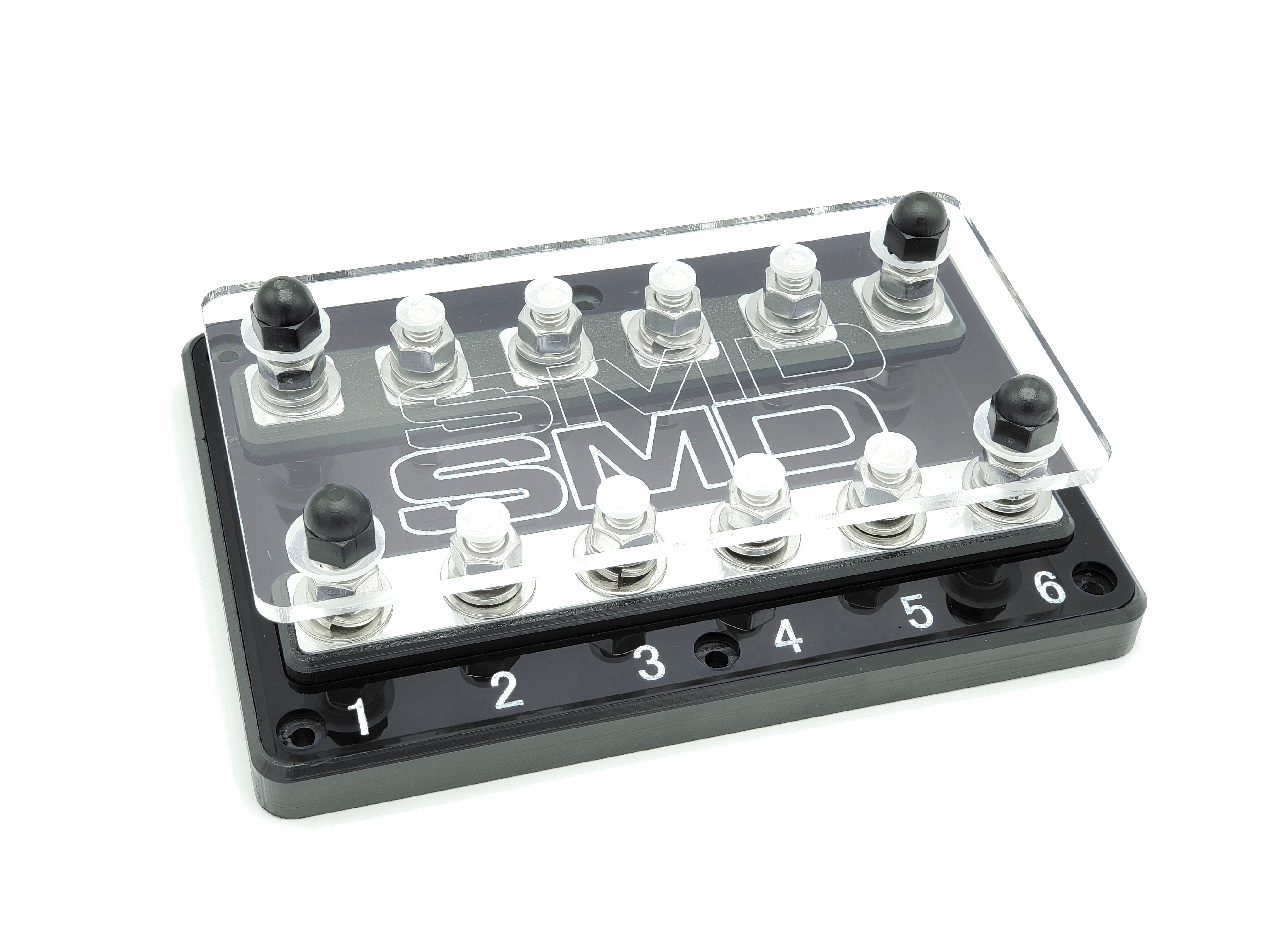 The SMD Hex 6-Spot ANL Fuse Block by Steve Meade Designs is a rectangular black and transparent fuse block with labeled numbers 1 to 6. It includes six pairs of terminals, each fitted with black and white knobs, and features the "SMD" label beneath the transparent cover. Perfect for aftermarket accessories, it provides dependable circuit protection.