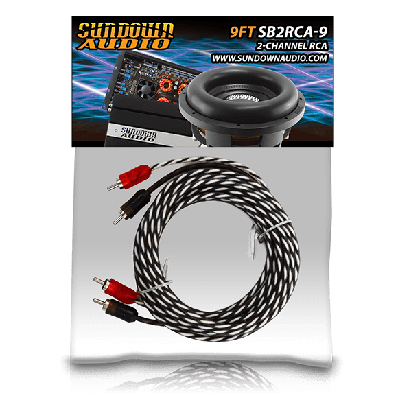 Coiled SB2-9FT black and white RCA interconnects with red/white connectors are showcased on a Sundown Audio display. A subwoofer and website URL appear atop the text: 9FT SB2RCA-9 2-Channel RCA. This solid conductor design ensures reliable audio transmission.
